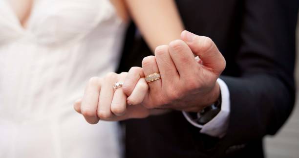 istock Holding hands, ring and couple on wedding with promise, celebration and marriage commitment. People, bride and groom with jewellery for partnership, relationship loyalty and ceremony announcement 2184712051