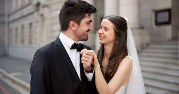 istock Happy, couple and holding hands on wedding with promise, celebration and marriage commitment. Smile, people and love with affection for partnership, relationship loyalty and romance ceremony at court 2184712062