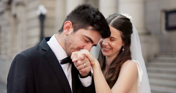 istock Smile, couple and kiss on hand for wedding with promise, celebration and marriage commitment. Happy, people and love with affection for partnership, relationship loyalty and romance ceremony at court 2184712066