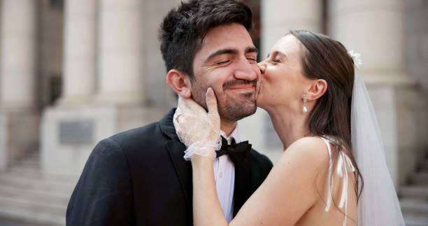 istock Smile, couple and kiss on cheek for wedding with promise, celebration and marriage commitment. Happy, people and love with affection of partnership, relationship loyalty and romance ceremony at court 2184712074