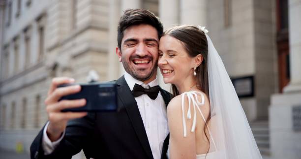 istock Couple, selfie and happy with wedding in city, love and care with commitment, memory and post on web. People, man and woman with marriage, event and celebration with smile on social media 2184712079