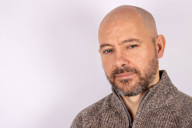 Side view of mature man standing against grey background.
