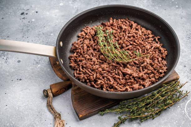 istock Frying Pan with fried mince beef meat, fresh cooked forcemeat. grey background. top view 2184717062