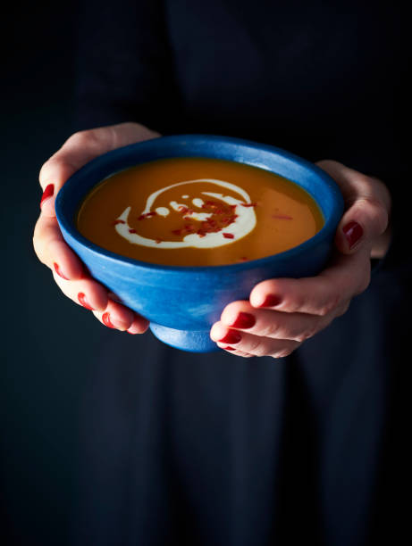istock Warming bowl of pumpkin soup held by hand 2184717387