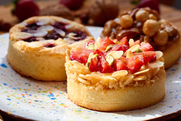 istock Three mini tarts cupcakes with strawberries, walnuts, almond, nuts and blueberries on plate 2184722148