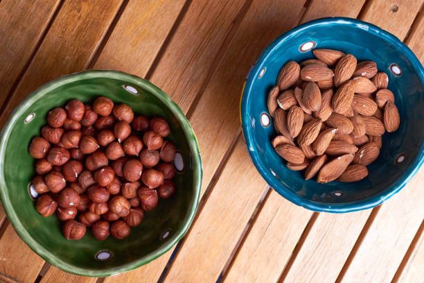Two bowls with almonds and hazelnuts. Top view