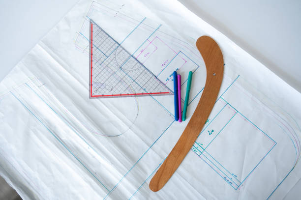 Clothing measurements drawn on white paper and tailoring materials on it