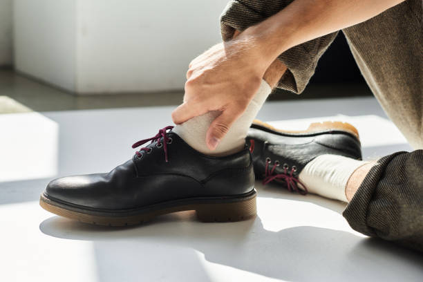 istock A stylish young man adjusting his black shoes in a bright studio during the day 2184722964