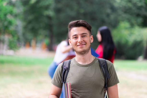 istock Smiling university student holding books on campus 2184725805