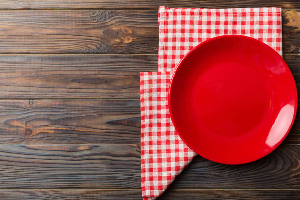 istock Top view on colored background empty round red plate on tablecloth for food. Empty dish on napkin with space for your design 2184727077