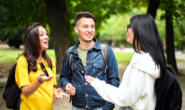 istock University students talking and walking in park during break 2184729381