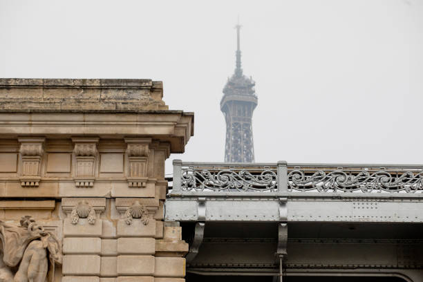 Detail of the Bir-Hakeim Bridge with the top of the Eiffel Tower in the distance
