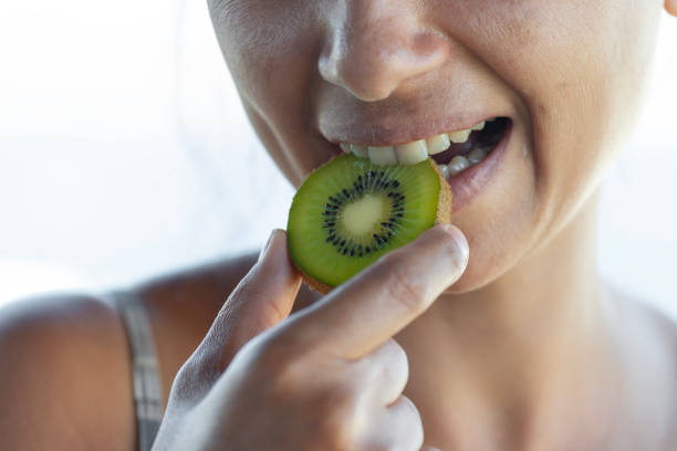 istock Woman Biting a Slice of Kiwi 2184736390