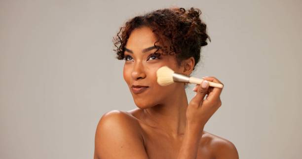 istock Woman, studio and smile with makeup brush for foundation and cosmetics application on gray background. Female person, isolated and happy for beauty with skincare, glow and blush for transformation 2184739297