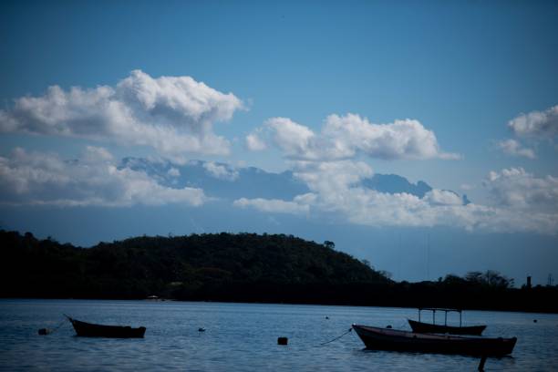 istock Boats on calm water with mountain and hill backdrop 2184743442