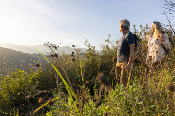 istock Mature couple look across hills to setting sun 2184750479