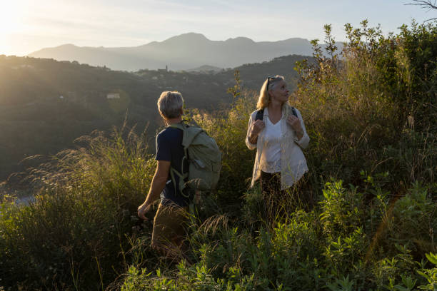 istock Mature couple look across hills to setting sun 2184750488