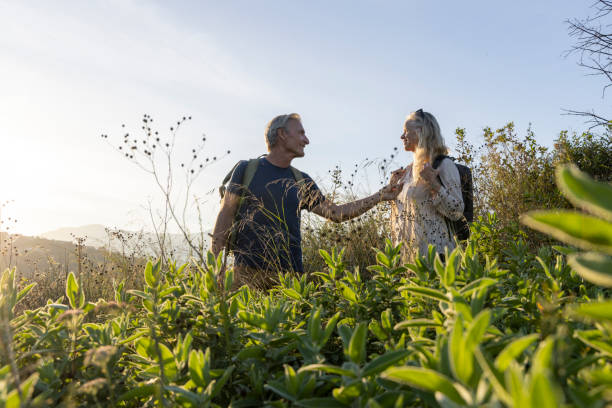 istock Mature couple look across hills to setting sun 2184750490