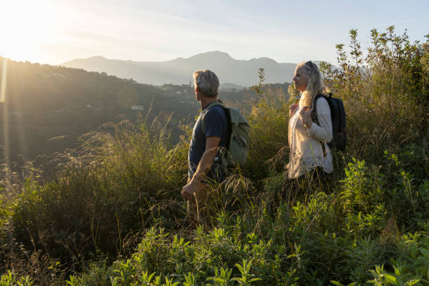 istock Mature couple look across hills to setting sun 2184750496