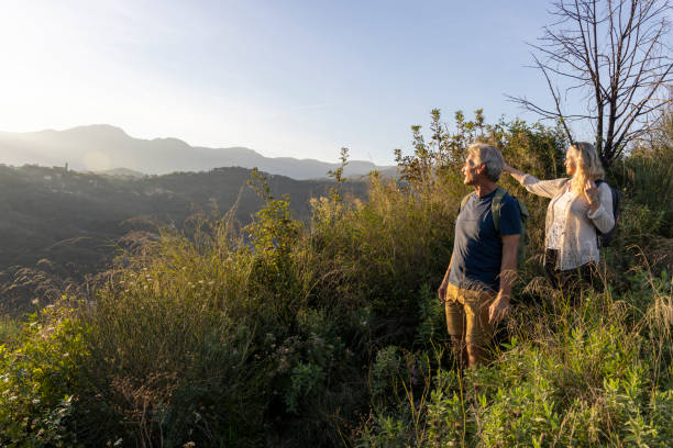 istock Mature couple look across hills to setting sun 2184750504