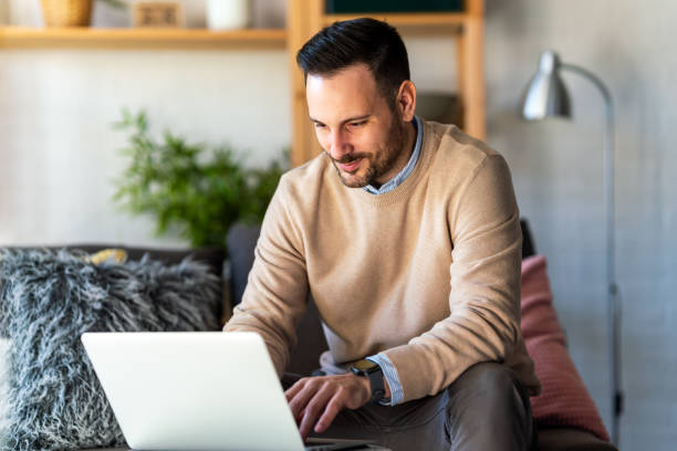 istock Satisfied with work done. Happy young man working on laptop while sitting at his working place 2184751665