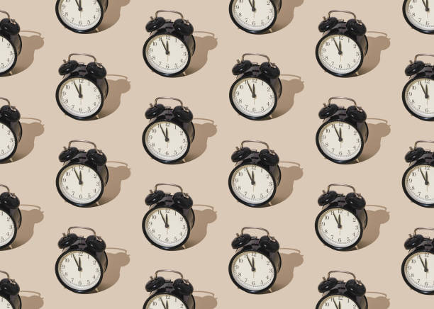 istock Trendy sunlight pattern made with retro alarm clock on pastel cream background. Minimal time concept. 2184755289
