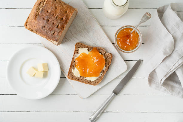 Whole grain bread with jam on a wooden table