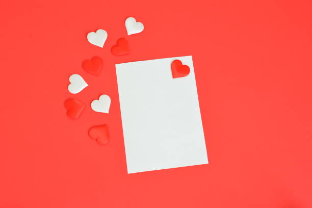 istock a white card with hearts on it and a red background with hearts on it 2184758683