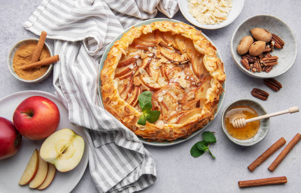 istock Delicious apple tart with almonds and honey served on a rustic table with fresh apples and spices 2184759199