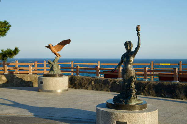 Gangneung City, South Korea - November 3rd, 2024: Bronze sculptures of a mermaid and a soaring bird decorate the courtyard of Jumunjin Lighthouse, adding artistic charm to this coastal landmark.