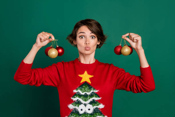 istock Photo of excited funny girl dressed ugly print pullover rising tree decorations lips pouted isolated green color background 2184760689