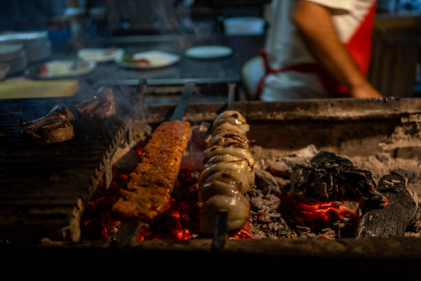 kebaps are on barbeque dishes are background focus on foreground chef is background horizontal food and beverage still