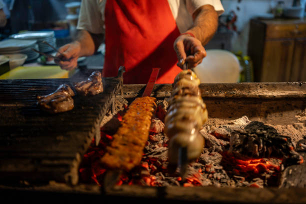 kebaps are on barbeque at foreground focus on foreground chef is background horizontal food and beverage still