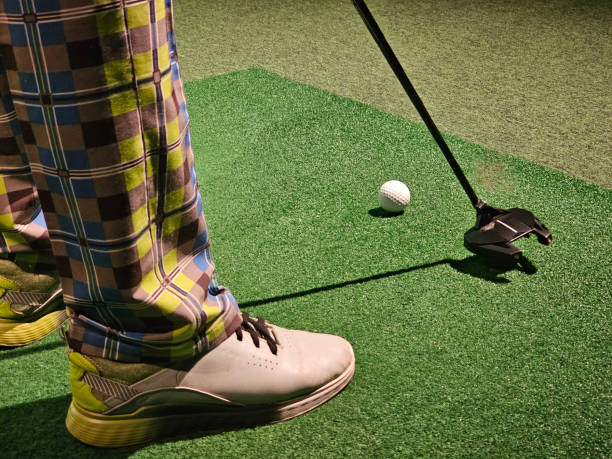 istock A man plays golf on a golf simulator and prepares to hit a shot. Practice putting in a golf simulator with a putter and a ball concept 2184761860