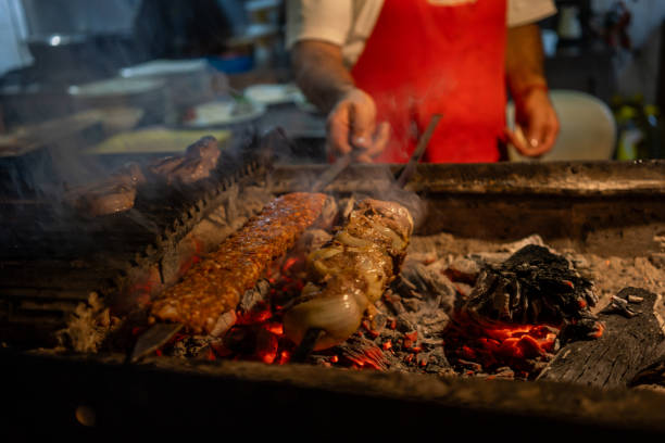kebaps are on barbeque dishes are background focus on foreground chef is background horizontal food and beverage still