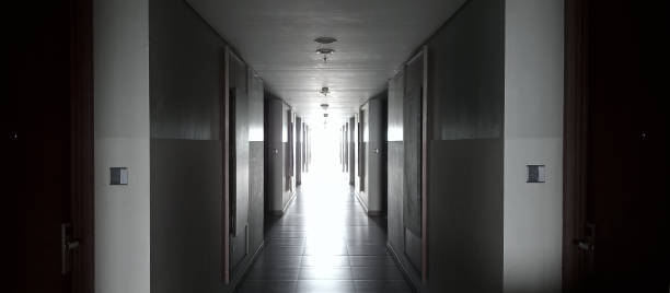 istock a long, illuminated hotel corridor with doors lining both sides. The corridor is evenly lit with light fixtures along the ceiling, creating a bright and inviting atmosphere. The neutral-toned walls 2184762170