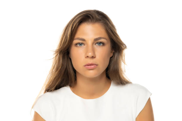 istock Portrait of young serious woman with a light makeup on a white studio background. 2184762667