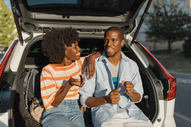 istock Couple chatting and relaxing together in car trunk 2184765321
