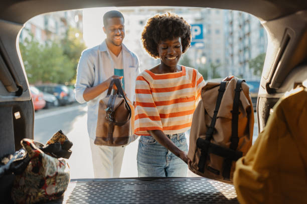 istock Packing bags into car trunk under bright sunny sky 2184765512