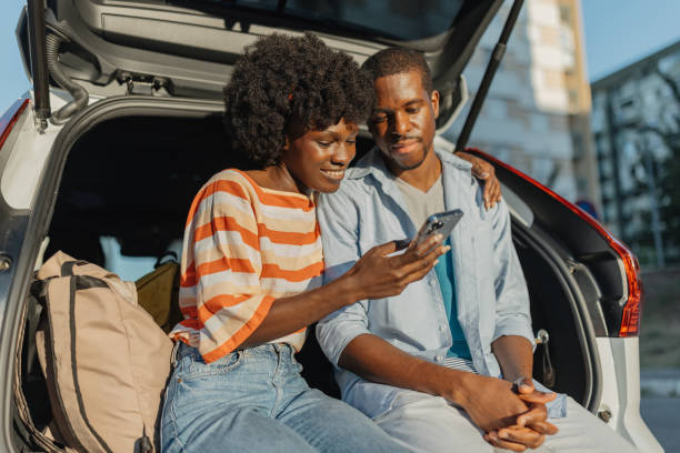 istock Couple sits joyfully in the back of a car trunk 2184765700