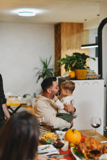 istock Father Holding and Embracing Son Having Bonding Moment on Dinner Party 2184766318