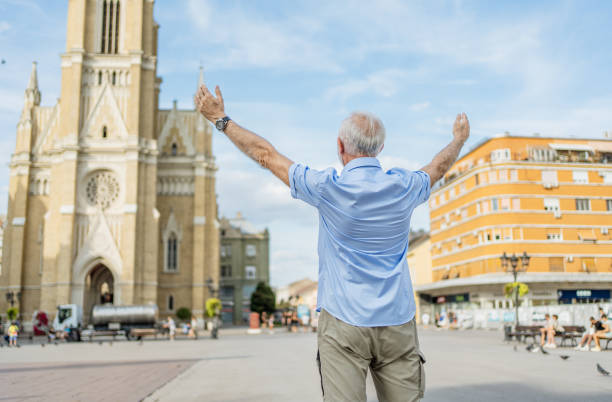 Happy senior man with arms outstretched in the city
