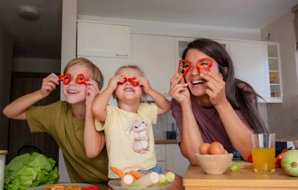 istock mom with her kids preparing lunch and playing with vegetables 2184769511