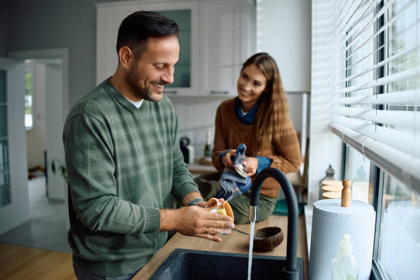 istock Smiling couple cooperating while doing the dishes together. 2184769685