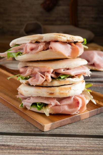 istock Stack of crescentine tigelle with mortadella and rocket on wooden board 2184776785