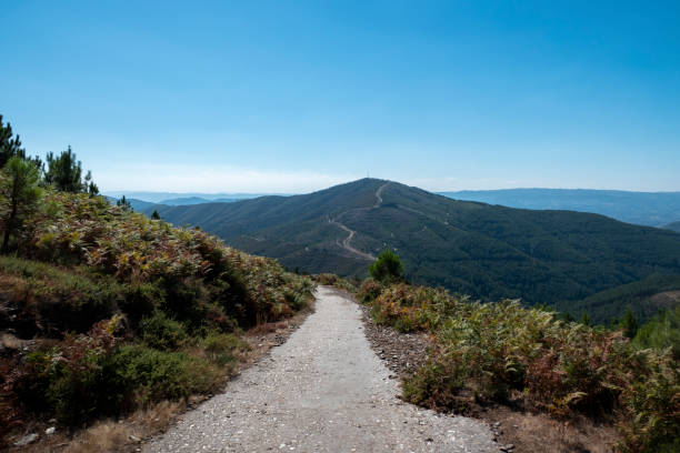 Path that descends over Fisgas de Ermelo in Serra do Alvão with more mountains in the background in Portugal