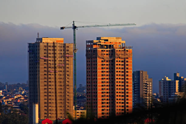 skyline at dusk, with two multi-story buildings under construction - MOGI DAS CRUZES,  SAO PAULO,  BRAZIL.