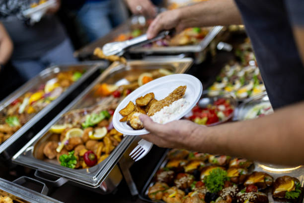 istock Delicious buffet spread featuring a variety of dishes, with a hand selecting fried chicken at a festive gathering 2184780062