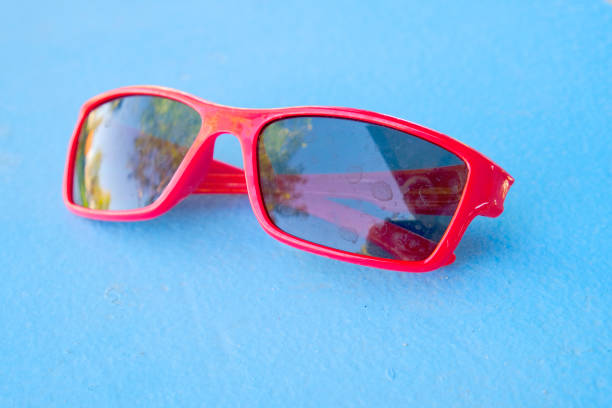 Red sunglassed laying on blue background surface visual weal fashion