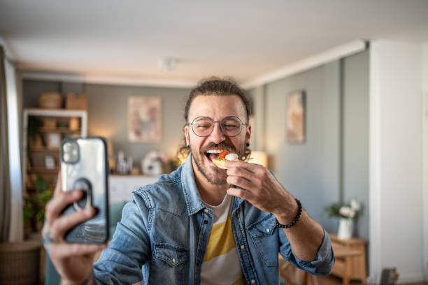 istock Hipster guy captures the moment with bruschetta in hand while taking a selfie 2184782054